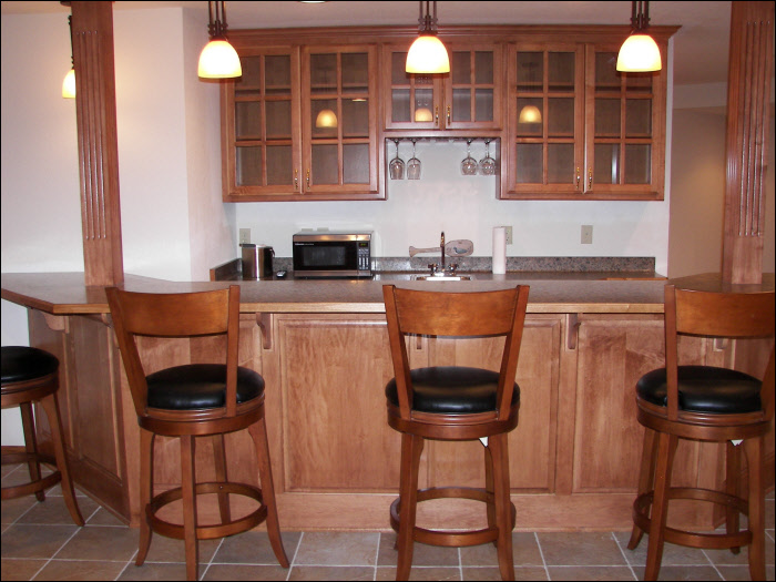 wet bar with maple custom cabinetry basement